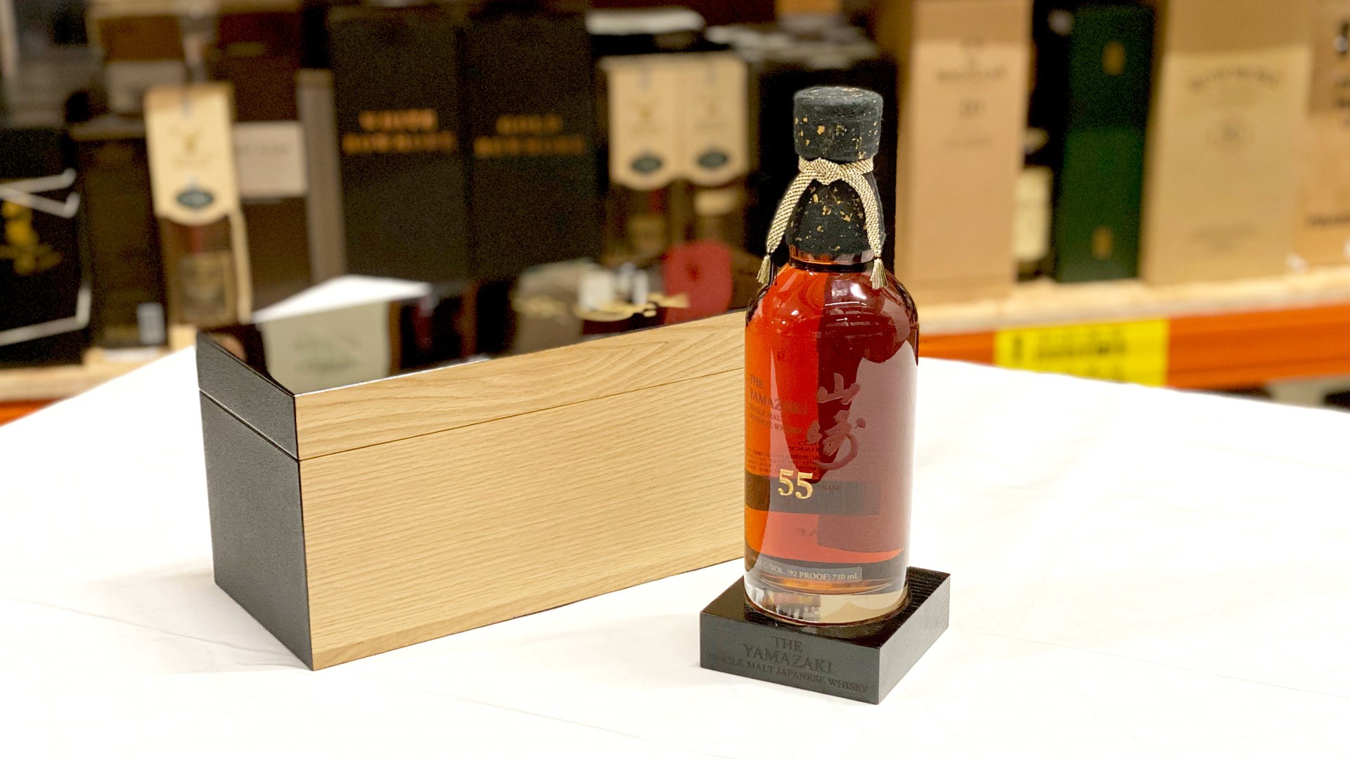 The Yamazaki 55 Years and the case made of Japanese Mizunara wood in the background on the table. 